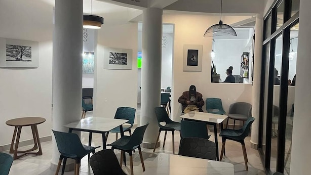A modern restaurant interior with tables and chairs, a visible counter, and framed pictures on the walls. - Hôtel H1 Fianarantsoa (Fianarantsoa)