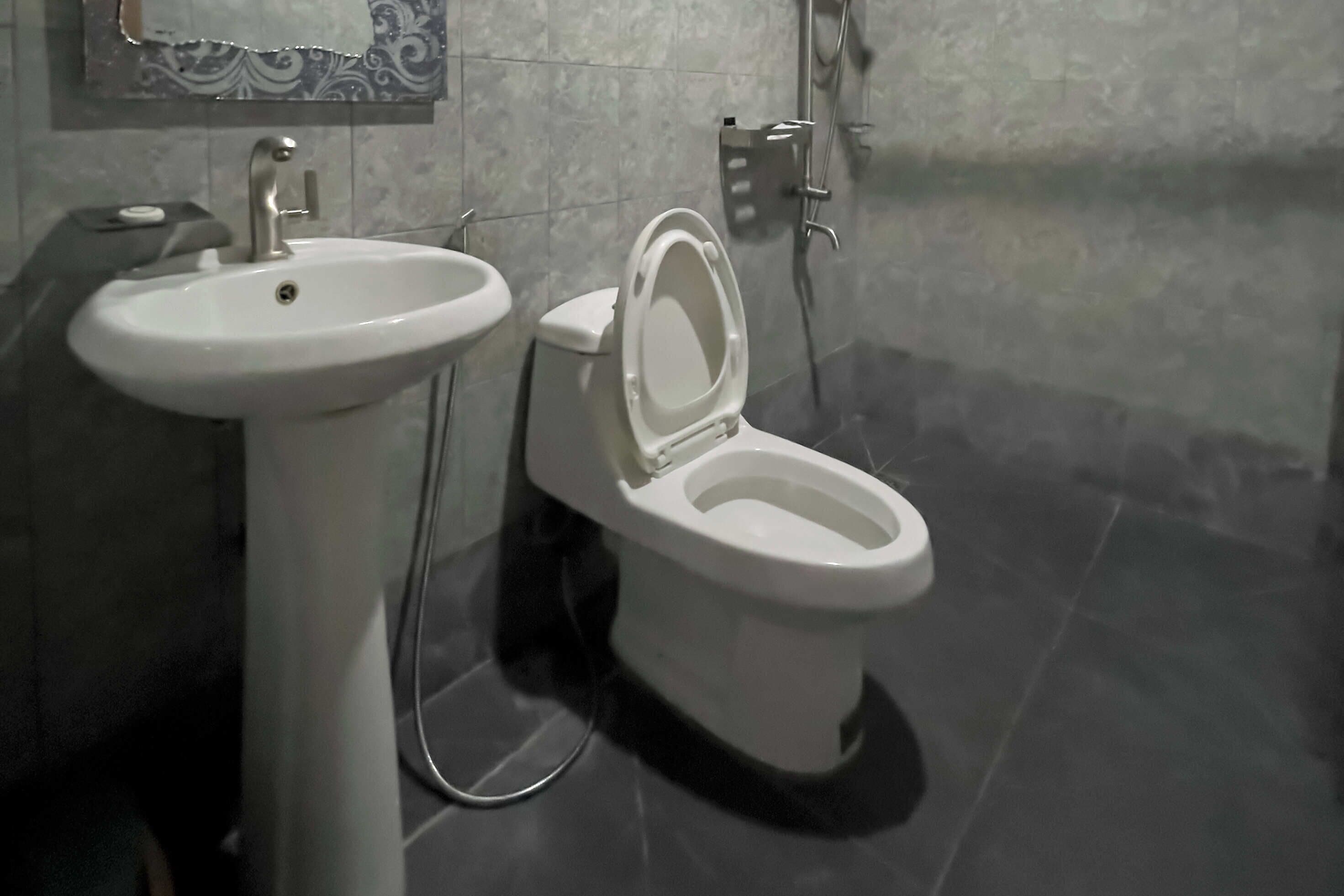 A bathroom with a white sink, toilet, and shower.