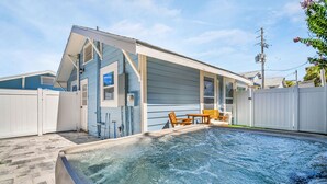 A residential property with a swimming pool, a covered patio, and a fenced backyard.