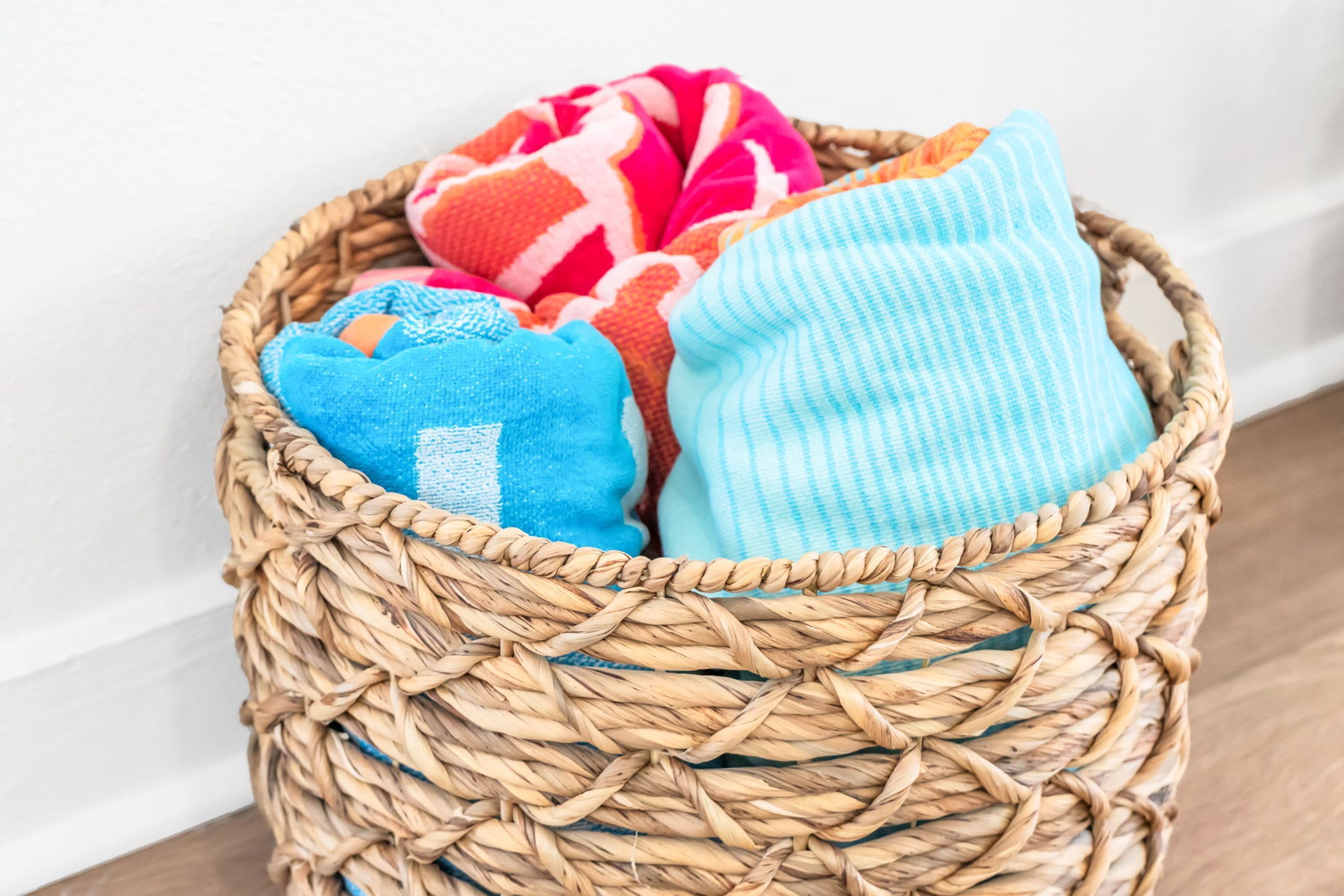 A wicker basket filled with colorful blankets.
