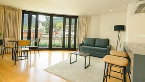 Een moderne woonkamer met een bank, een salontafel en een eethoek met stoelen.