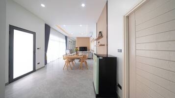A modern interior with a dining area, kitchen, and a large sliding door.