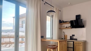 Une cuisine moderne avec des plans de travail en bois, un réfrigérateur en acier inoxydable et un tabouret en bois.