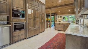 A spacious kitchen with wooden cabinets, stainless steel appliances, and a large island. - Hot tub, Outdoor dining, BBQ Grill, Fire pit & Gym (Colorado Springs)