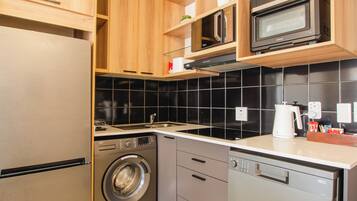 Een praktische keuken met een wasmachine, een magnetron en een vaatwasser.