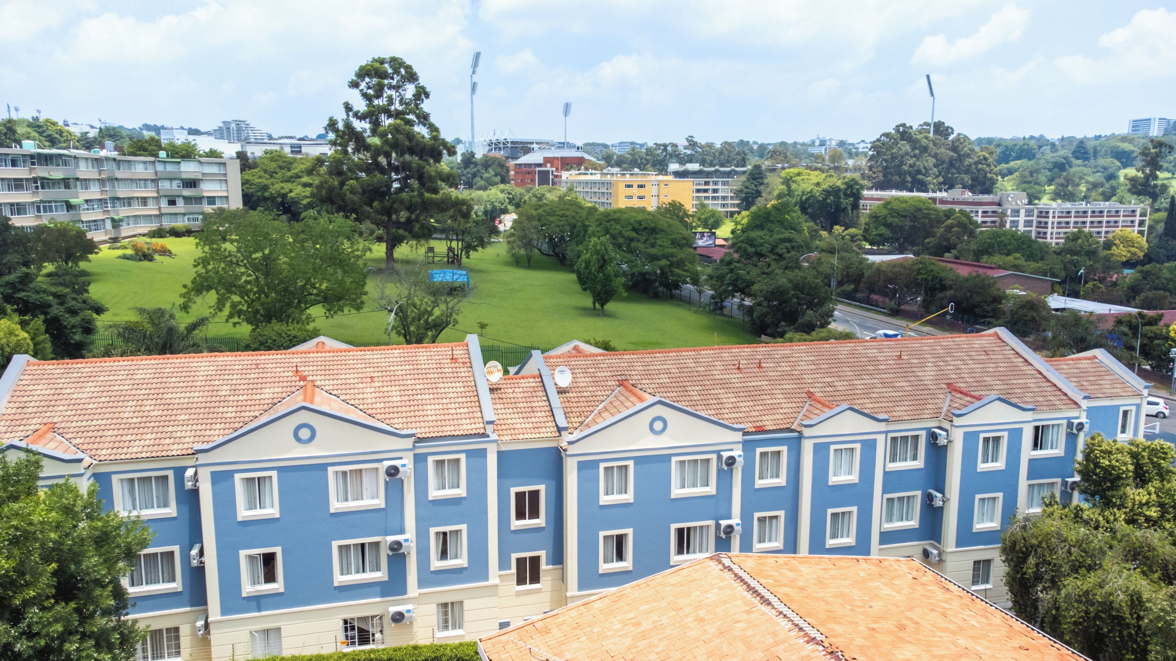 A multi-story residential building with a red-tiled roof and blue exterior walls.