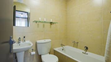 A bathroom with a sink, toilet, and bathtub.