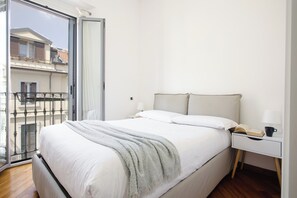A bedroom with a bed, bedside table, and a view of a balcony. - Lovely 1-bed apt next to the City Centre (Milan)