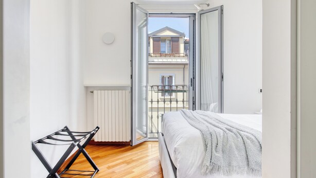 A bedroom with a bed, a radiator, a window, and a balcony. - Lovely 1-bed apt next to the City Centre (Milan)