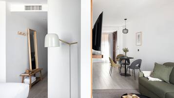 A modern hotel room with a bed, a wooden bedside table, a mirror, and a lamp.