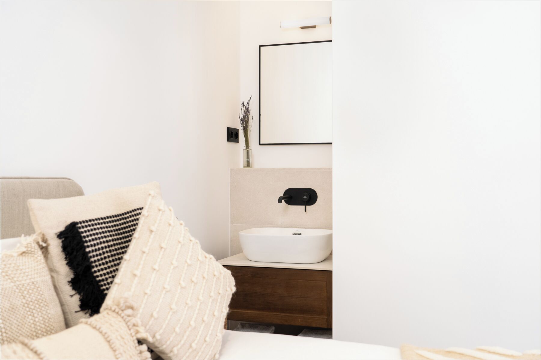 A modern bathroom with a white sink, a mirror, and a towel rack.