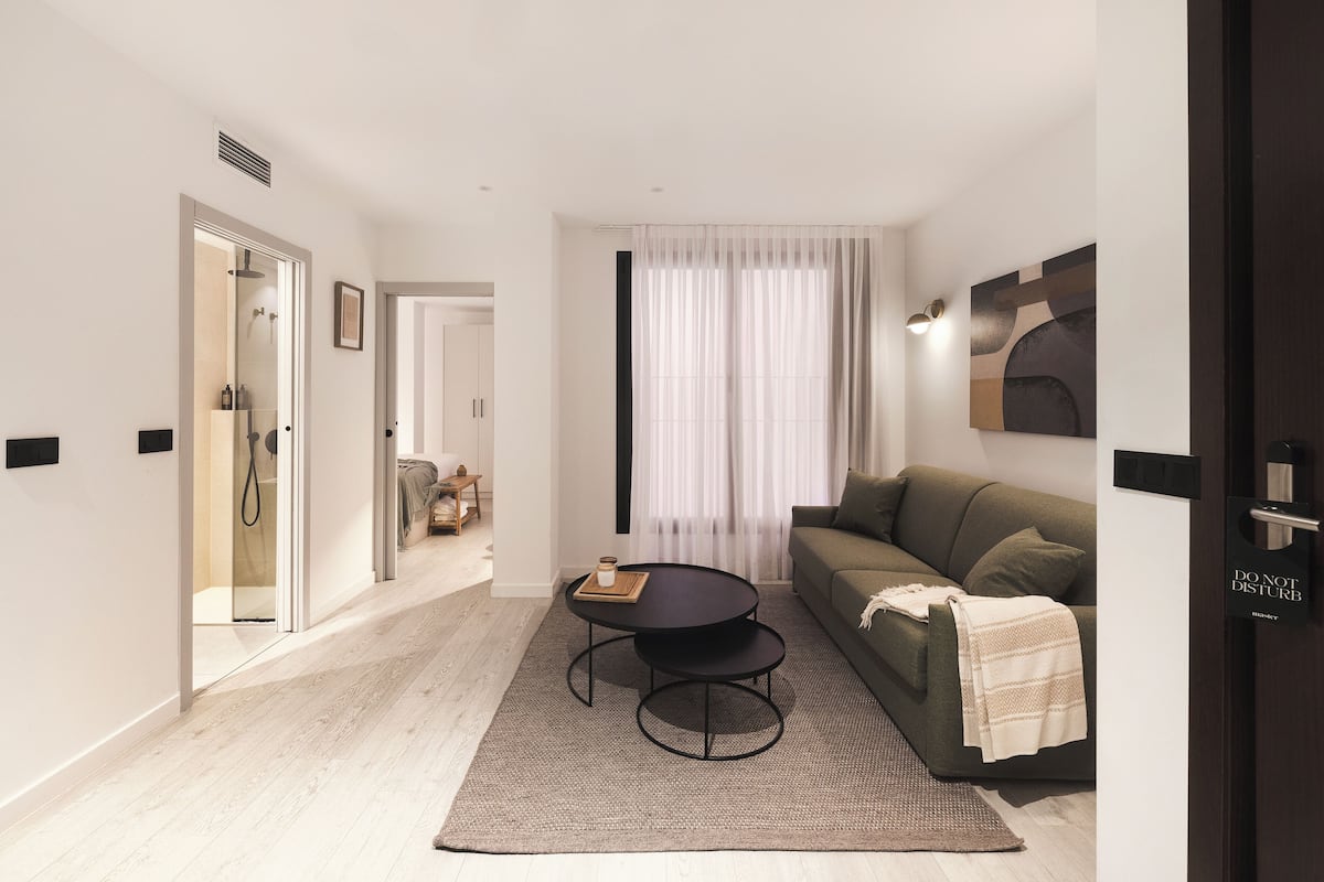 Uma sala de estar moderna com sofá, mesa de centro e porta de chuveiro de vidro.