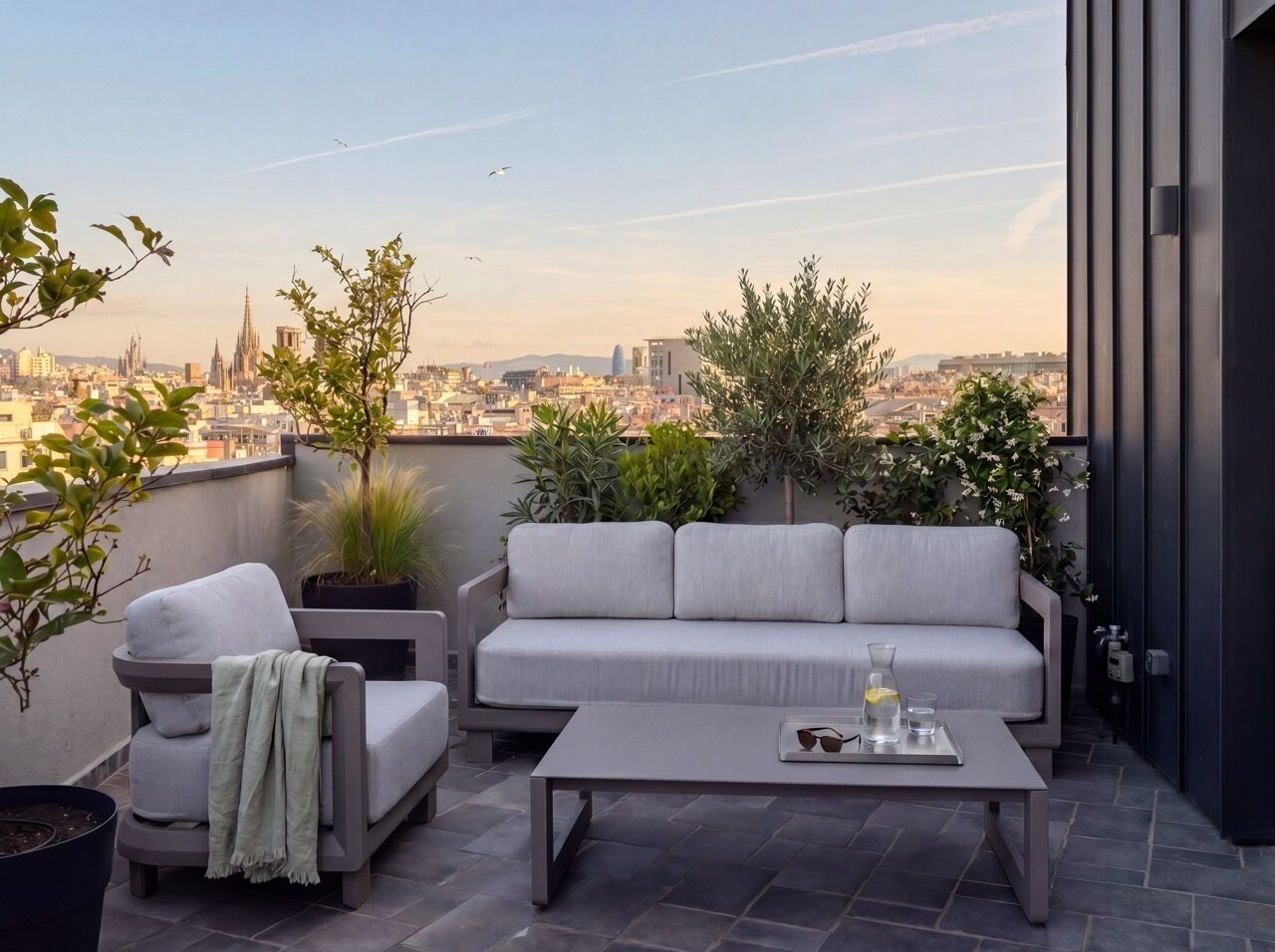 Una terraza en la azotea con un sofá, sillas y una mesa de centro.