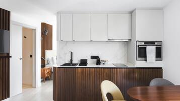 A modern kitchen with a wooden island, white cabinets, and a built-in oven.