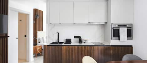 A modern kitchen with a wooden island, white cabinets, and a built-in oven.
