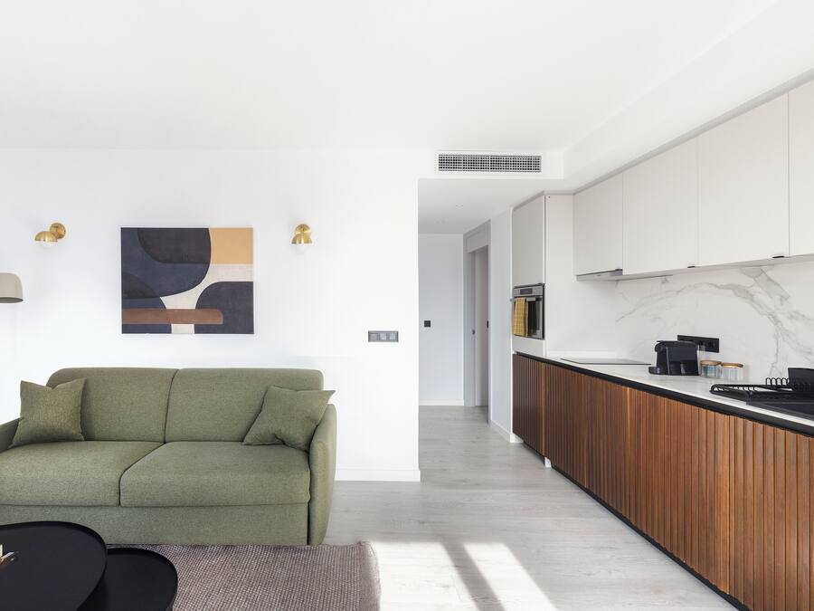 Una sala de estar moderna con un sofá verde, una mesa de centro y un cuadro en la pared.