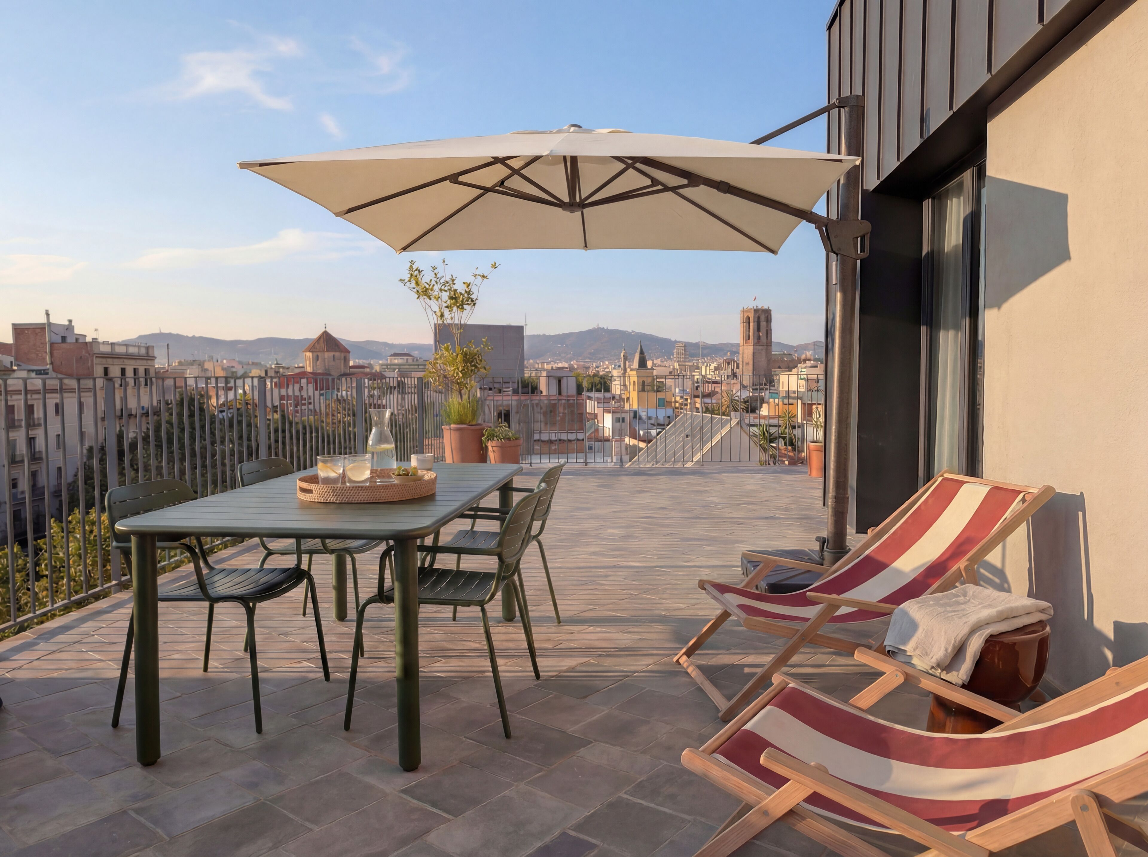 A terrace with a table, chairs, an umbrella, and a view of the cityscape.