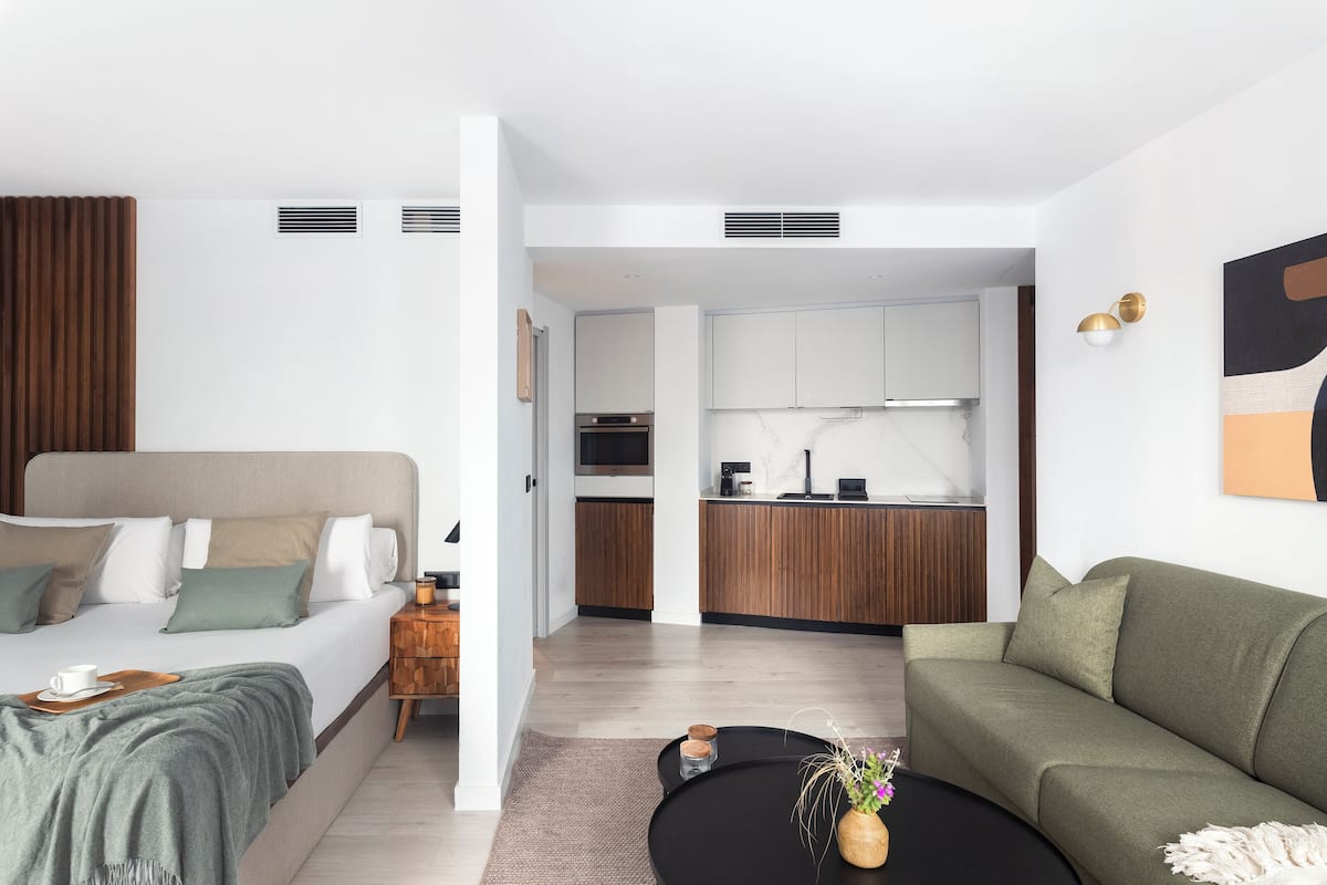Um apartamento moderno com um quarto, sala de estar e cozinha.