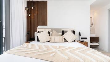Un dormitorio moderno con una cama grande, varias almohadas, una mesita de noche y un panel de pared de madera.