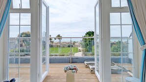 A balcony with a view of the sea, a wooden deck, and a white balustrade. - A family house that sleeps 12 guests  in 6 bedrooms (Bognor Regis)
