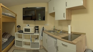 A compact kitchenette with a microwave, coffee maker, and sink. - Small apartment for two people with garden and private entrance (Bochum)