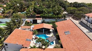 Zona residencial con varios edificios, piscina y abundante vegetación.