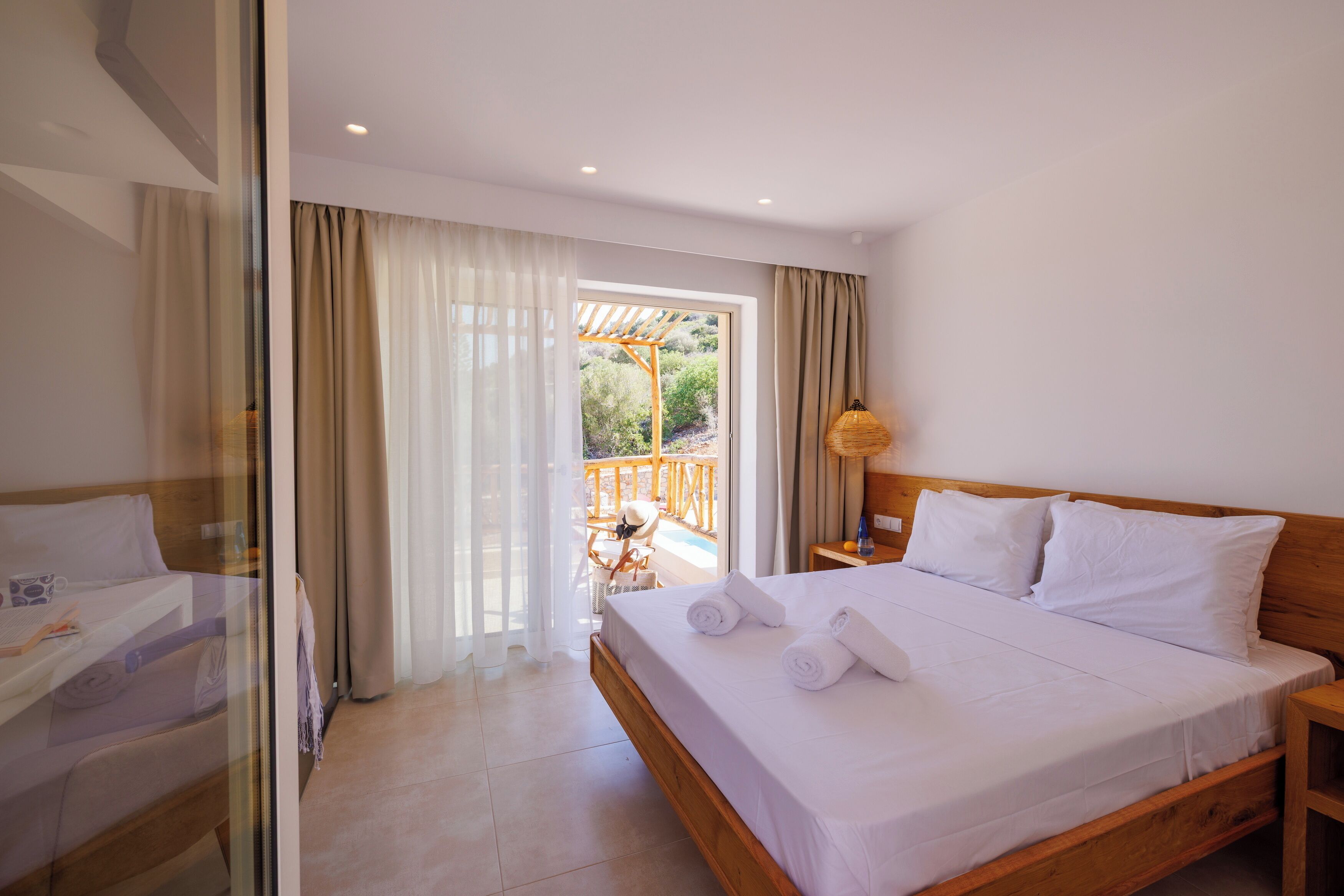 Une chambre d’hôtel avec un lit, un bureau et une vue sur un espace extérieur comprenant une piscine.