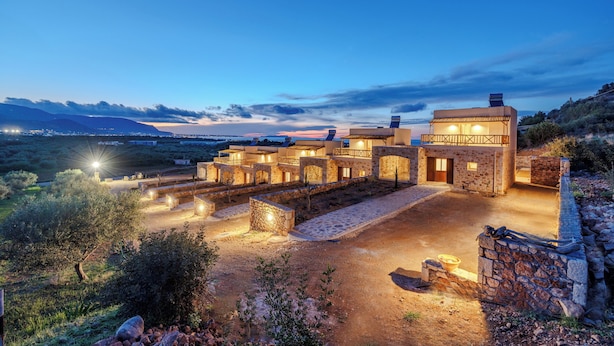 A modern villa with multiple bedrooms, a stone courtyard, and a view of the surrounding landscape. - Minoan Villas (Malia)