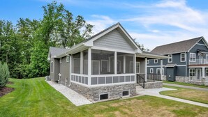 A two-story house with a covered porch, stone foundation, and a well-maintained lawn. - Pet-friendly Getaway With Golf & Private Patio Retreat 4 Bedroom Home (South Bend)