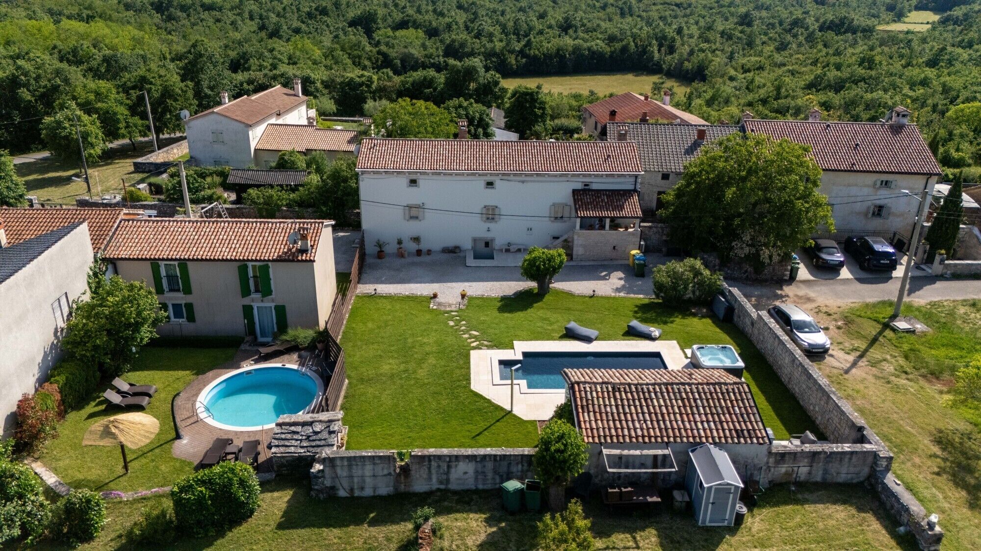 Une propriété résidentielle dotée d’une piscine, d’un jacuzzi et d’une pelouse bien entretenue.