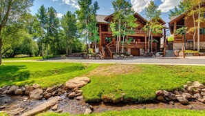 Un chalet doté de fondations en pierre, de balcons en bois et d’un chemin en pierre menant à l’entrée.