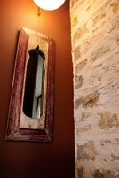 A mirror with a rustic wooden frame mounted on a textured wall.
