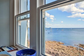 A room with a large window overlooking a beach with boats and clear skies. - Rock House, Kingsand (Kingsand)