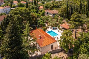 Zona residencial com piscina cercada por árvores e casas.