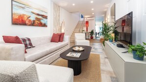 Ein modernes Wohnzimmer mit einer Couch, einem Couchtisch und einem Gemälde an der Wand.