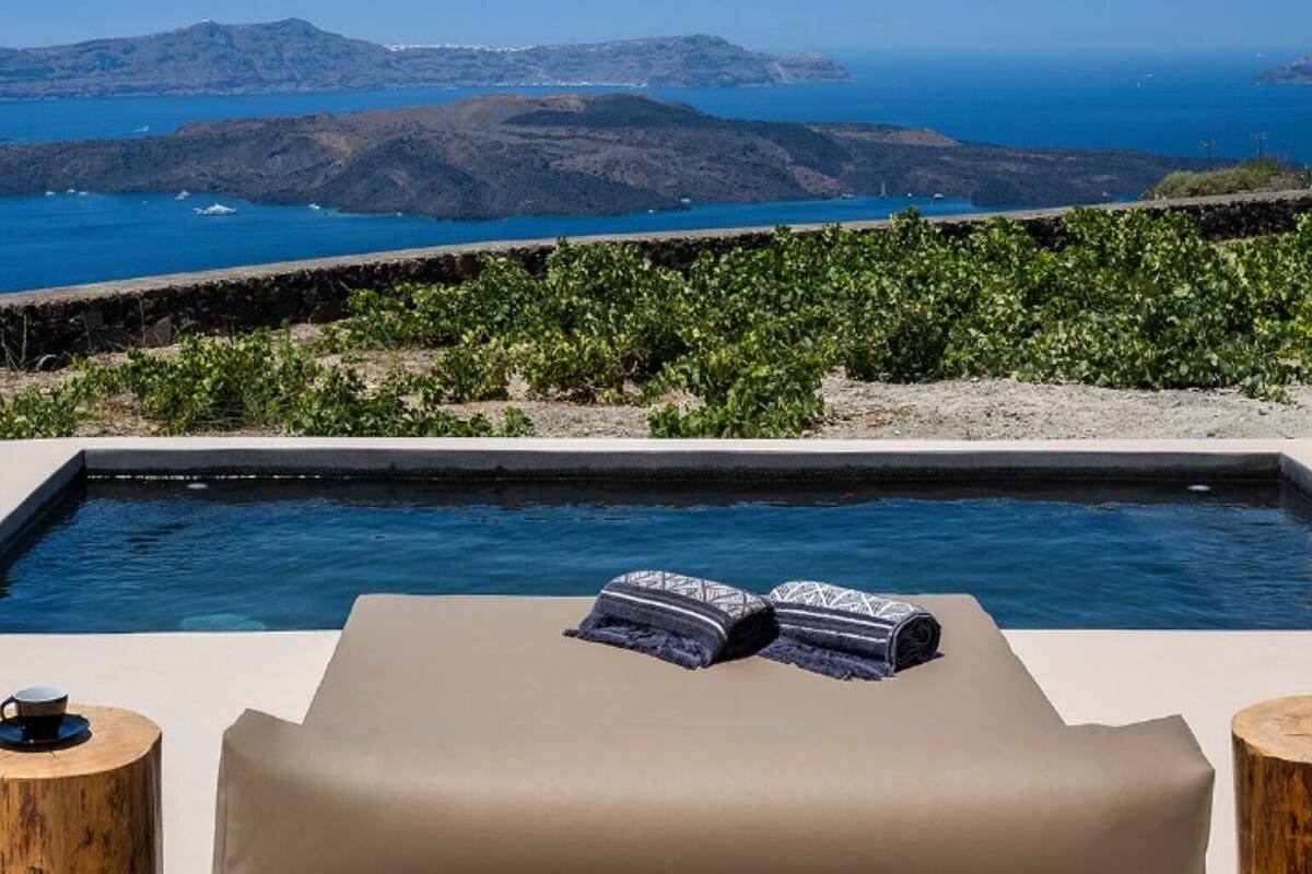 A rooftop infinity pool with a view of the sea and islands.