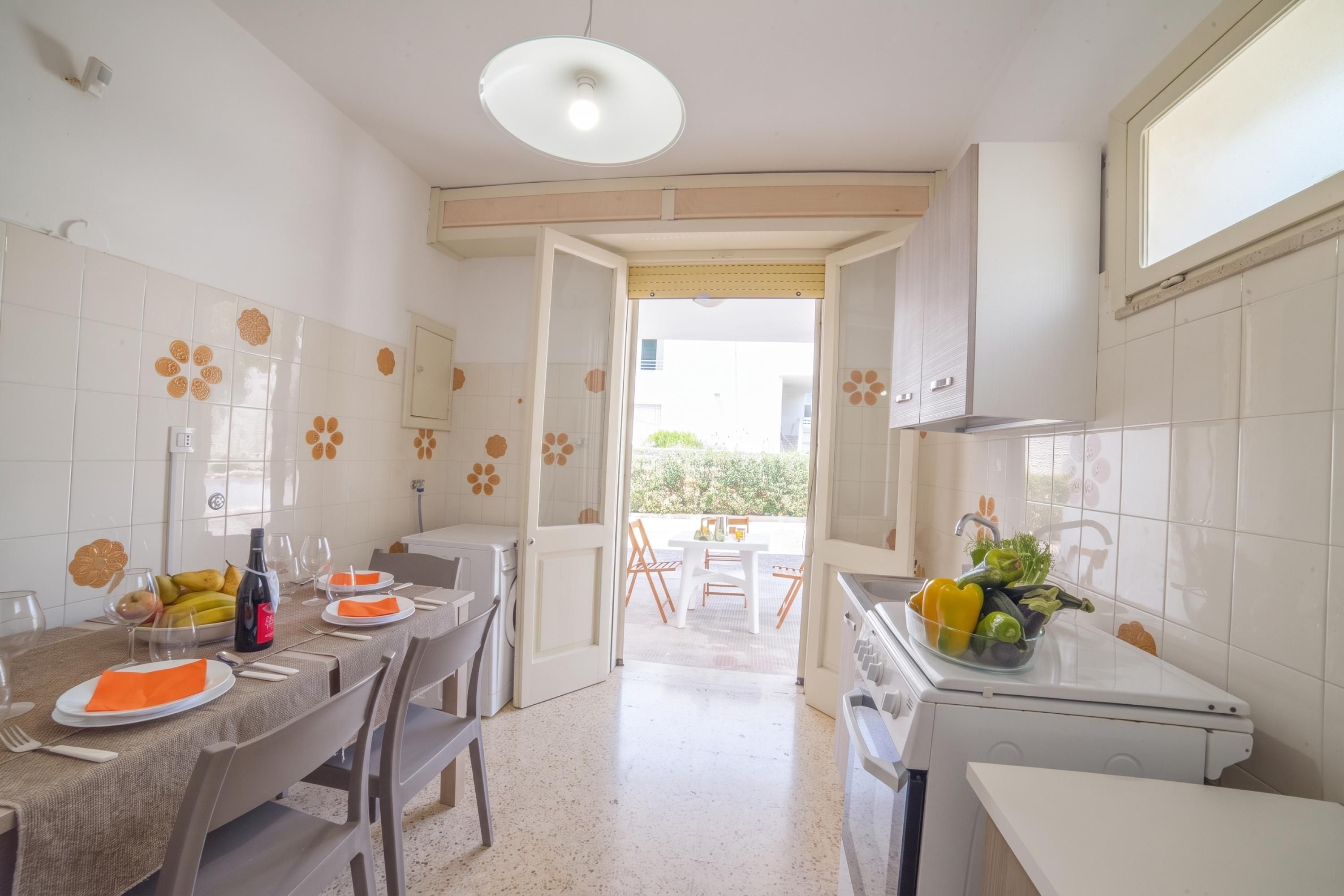 A kitchen with a dining area, a washing machine, and a sink.