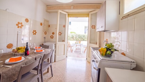 A kitchen with a dining area, a washing machine, and a sink. - Giulia Sea View Villas (Santa Cesarea Terme)