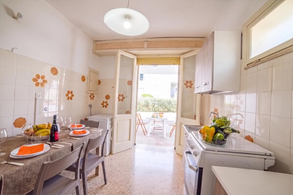 Una cocina con comedor, lavadora y pileta.