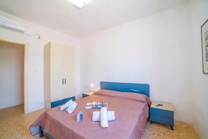 A bedroom with a bed, a nightstand, a wardrobe, and a ceiling light. - Giulia Sea View Villas (Santa Cesarea Terme)