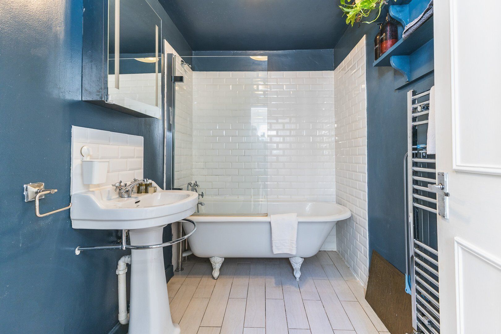 A bathroom with a white bathtub, a sink, and a mirror.