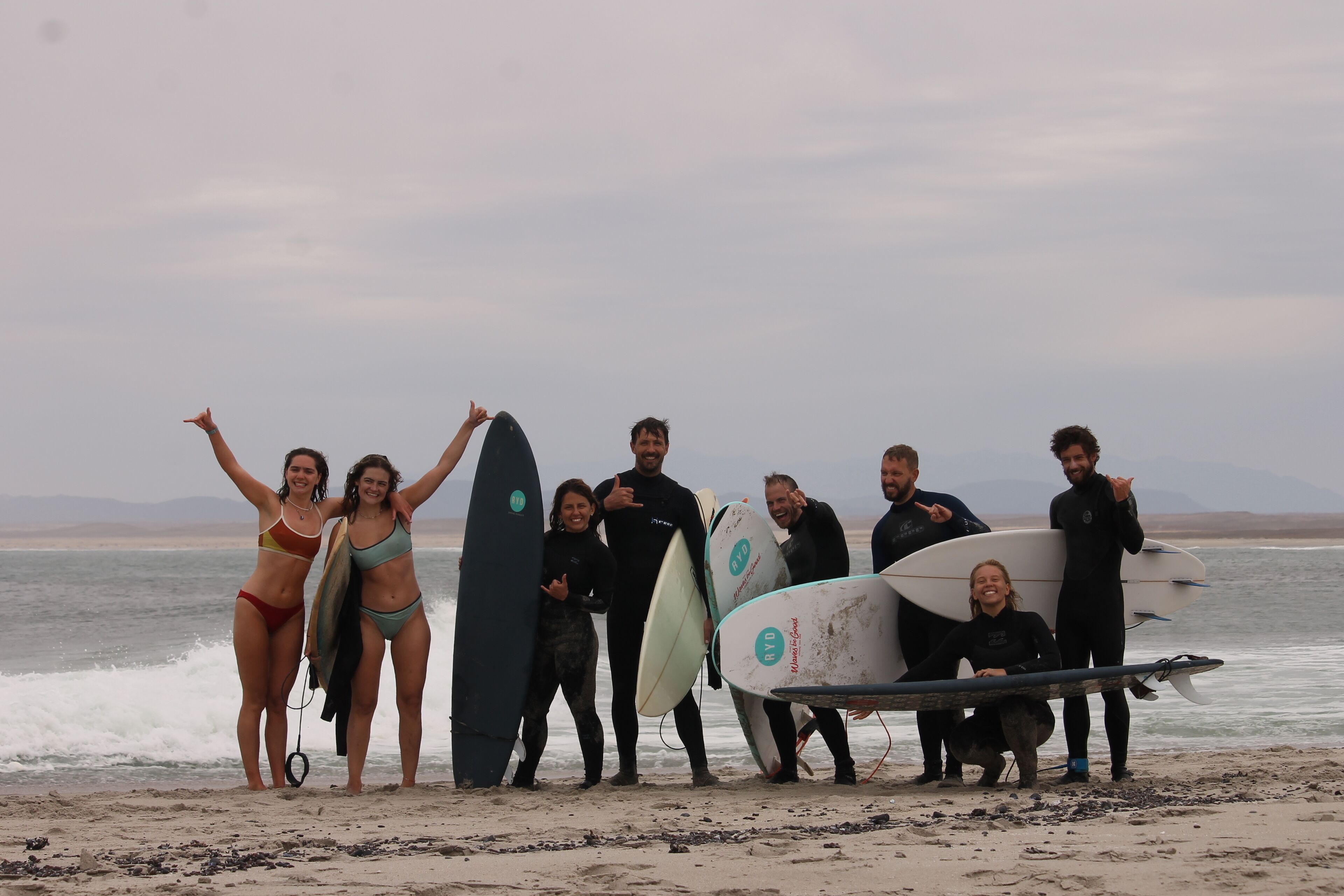 A group of people with surfboards on a beach.