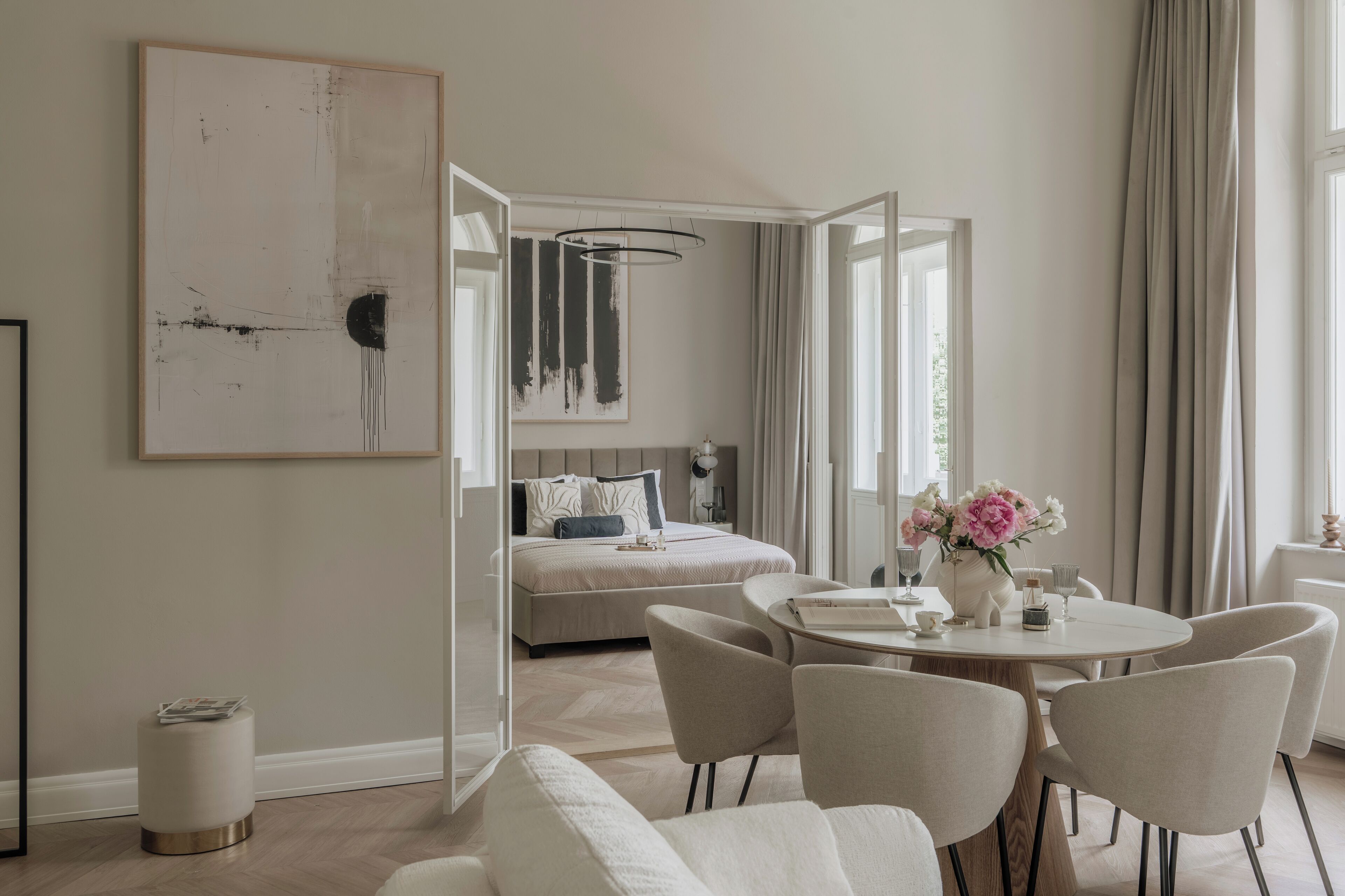 Une chambre à coucher moderne avec un lit, une table de chevet et un grand tableau abstrait.