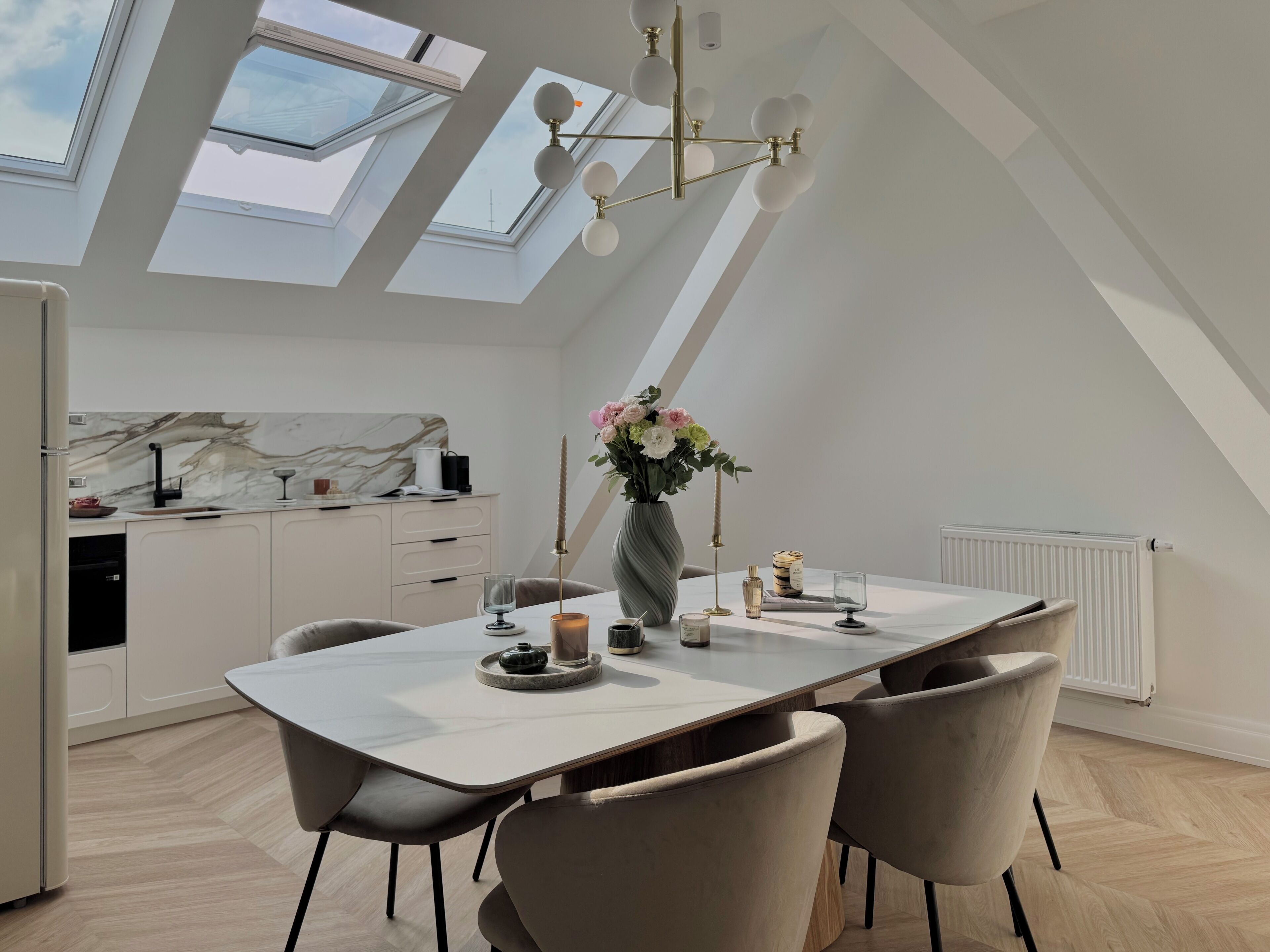 Eine moderne Küche mit Oberlicht, einem Essbereich mit Tisch und Stühlen sowie einer Heizung.