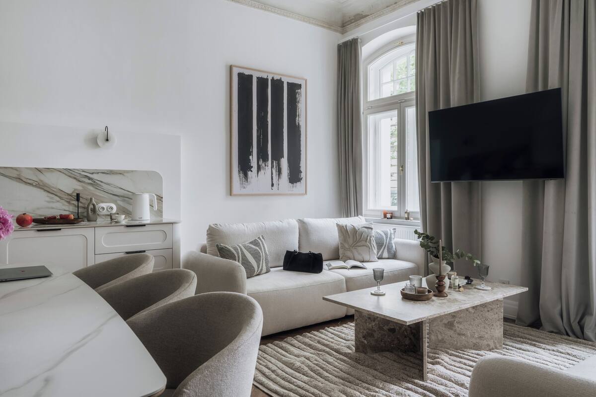 A modern living room with a sofa, coffee table, and a flat-screen TV.
