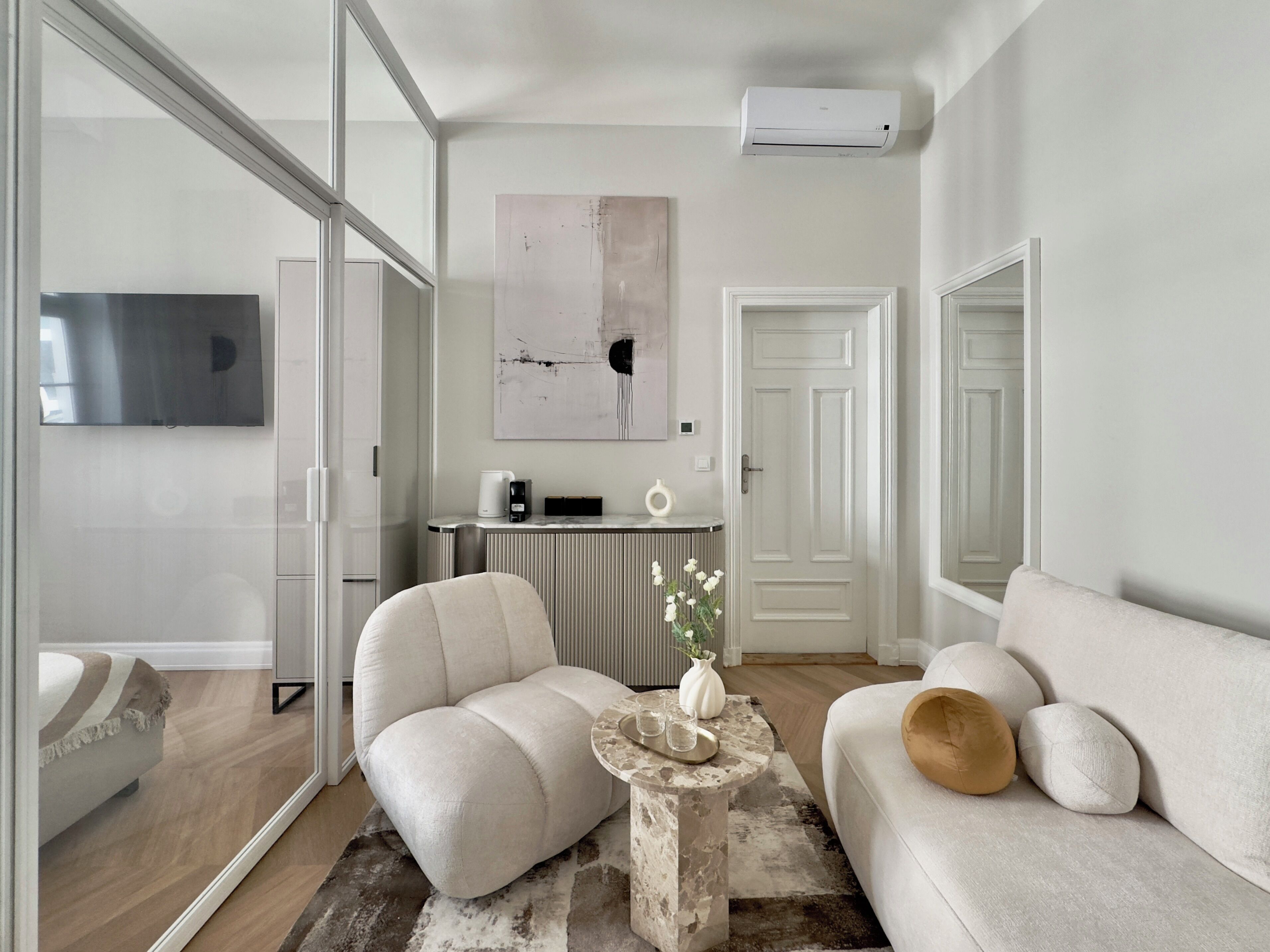 A modern living room with a sofa, a chair, a coffee table, and a TV.