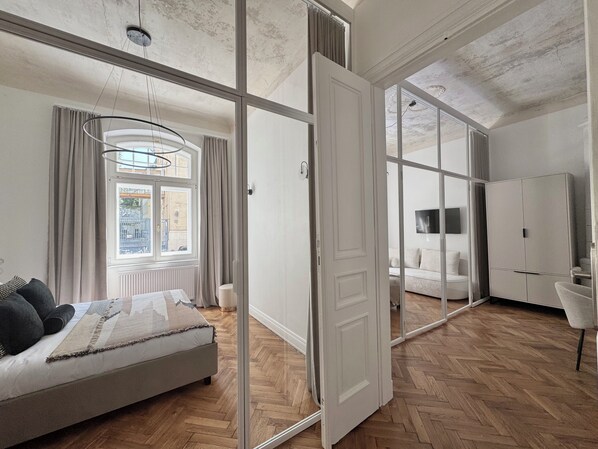 A modern bedroom with a large bed, a wardrobe, and a TV.