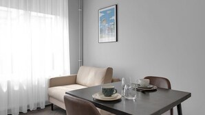 A minimalist room with a sofa, a table, and a framed picture on the wall.