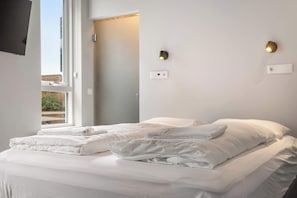 A hotel room with a bed, two wall-mounted light fixtures, and a window. - Swan Stylish Double Studio (Reykjavík)