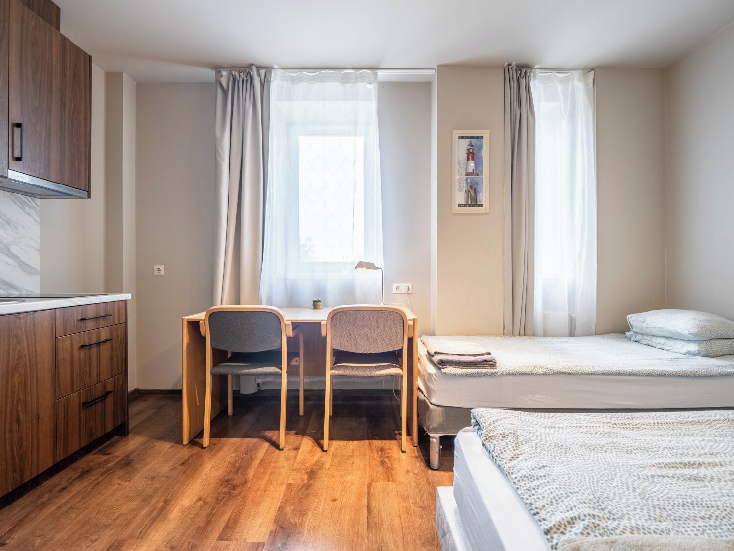 Une chambre à coucher de taille réduite, comprenant un lit, un bureau et des chaises.